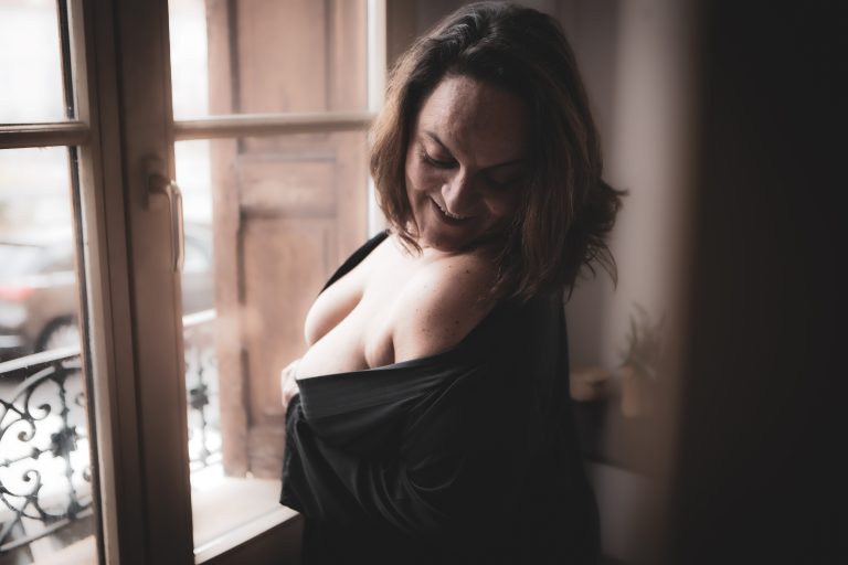 photo intimiste d'une femme devant une fenêtre
