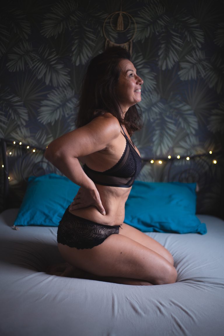photo intimiste de femme qui sourit en regardant par la fenêtre